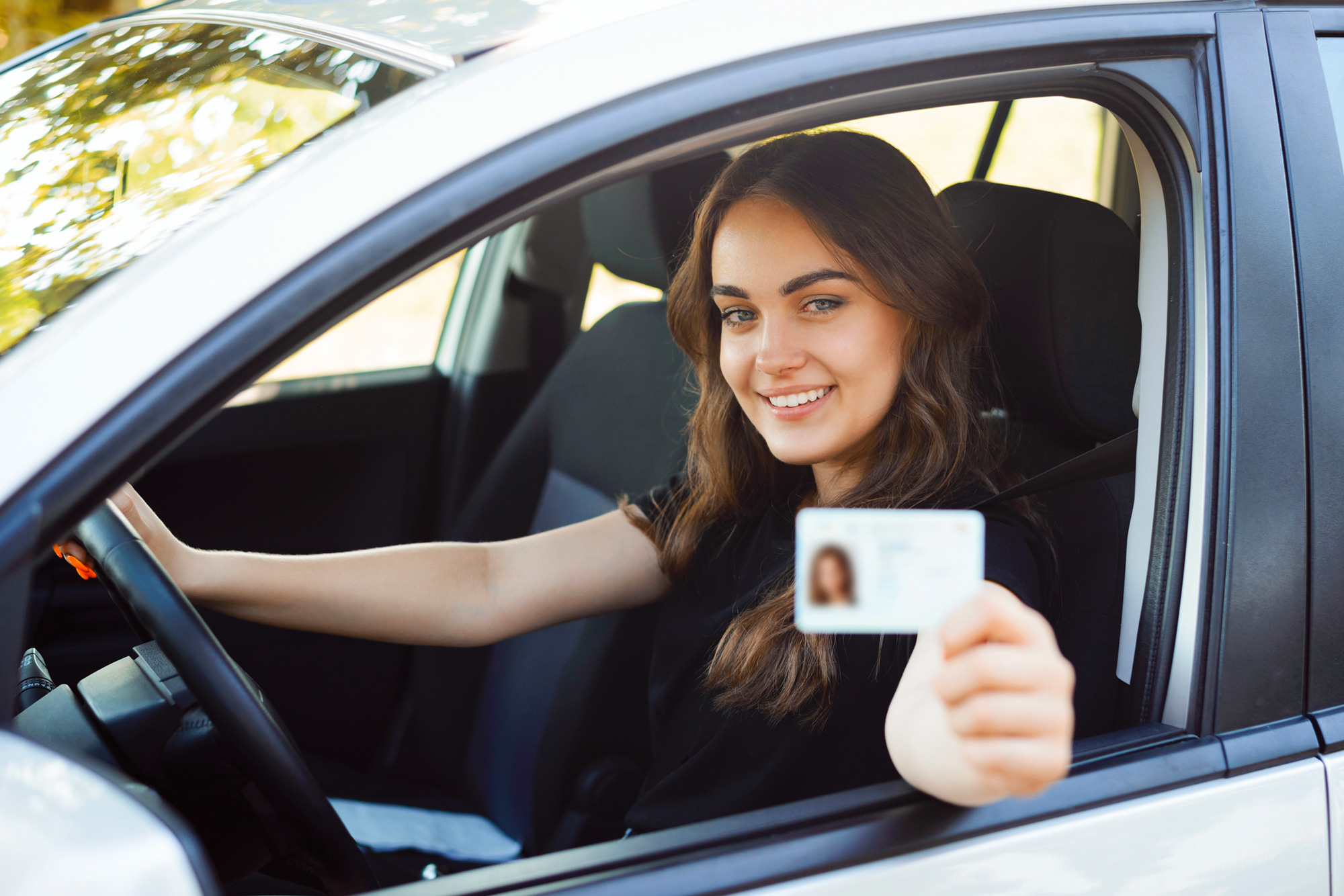 A lady showing her Driving License from car