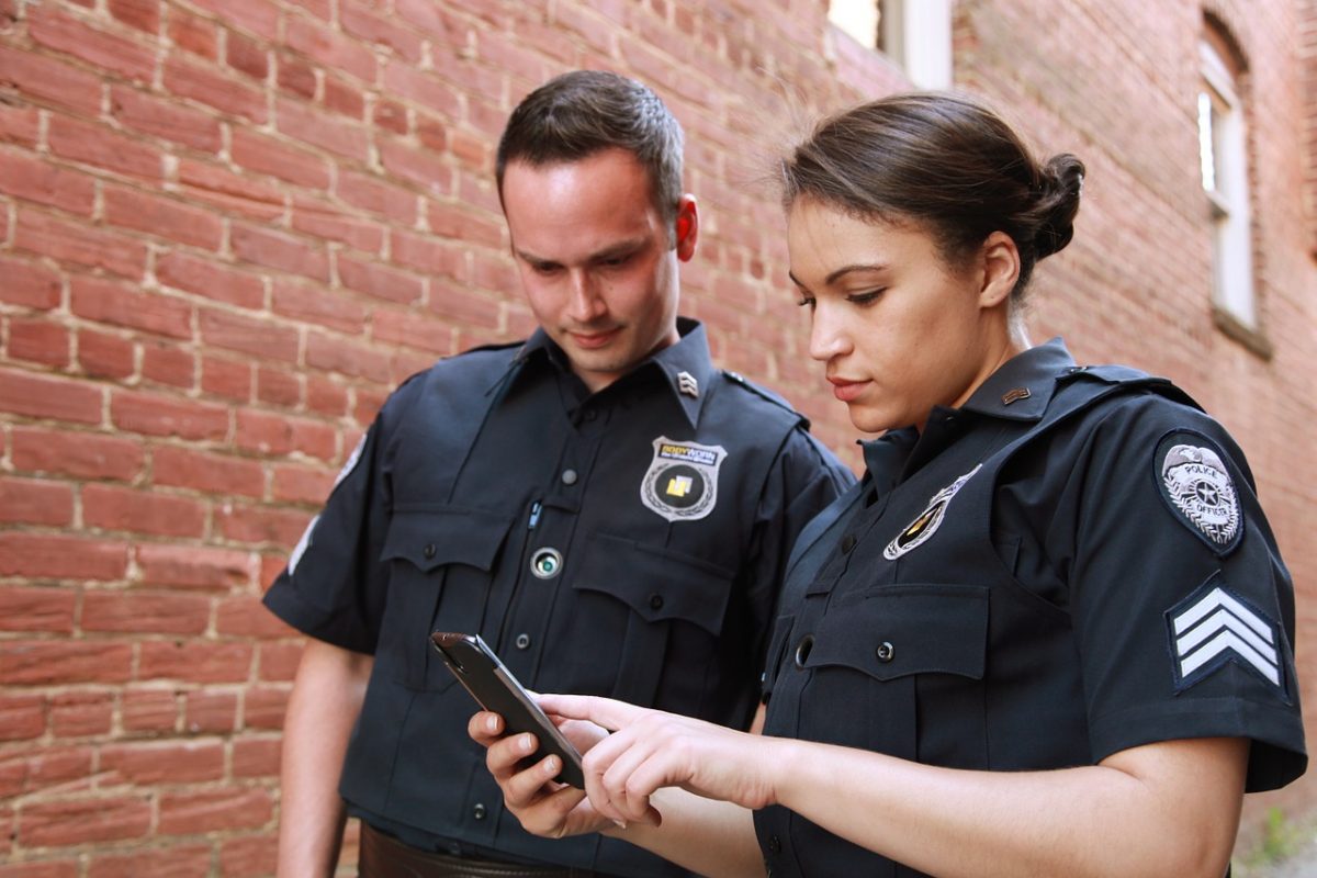 One male and one female police officer looking at their phone